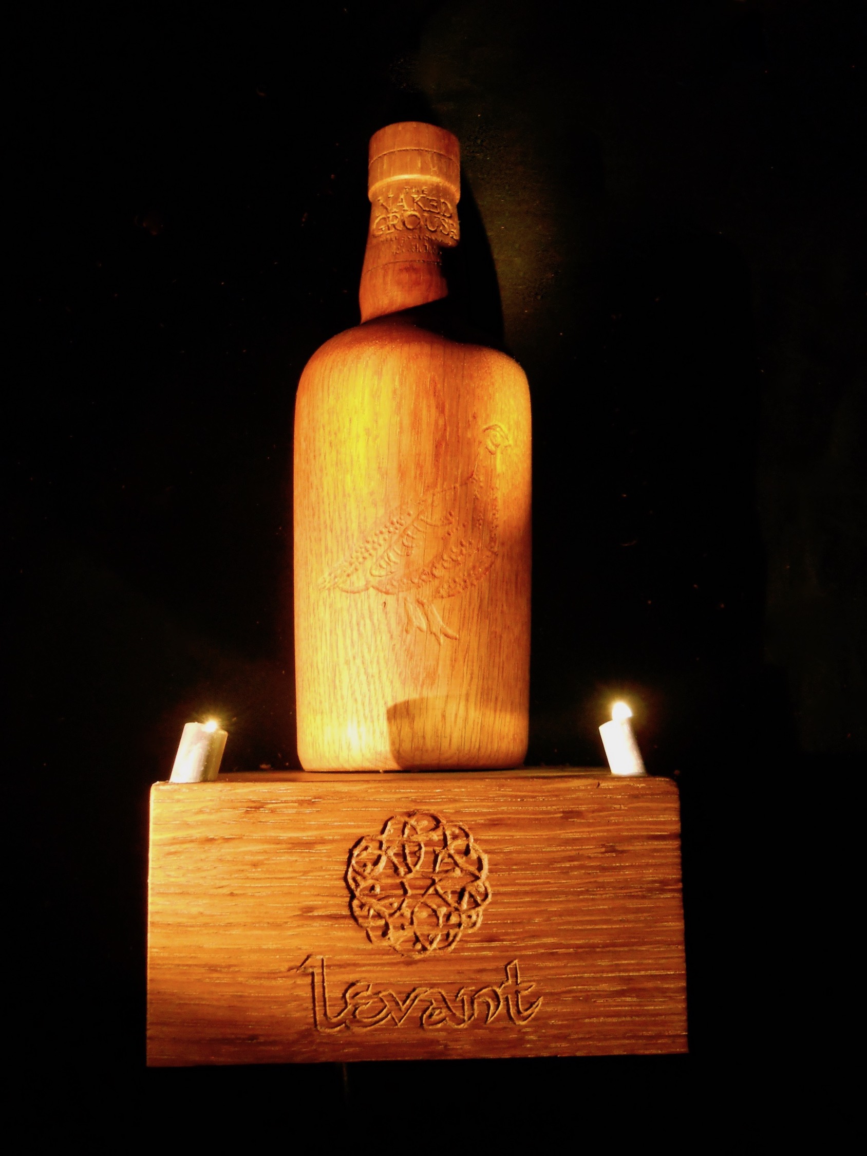 wooden sculpture of a naked grouse whisky bottle
