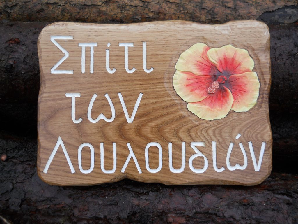 house sign with Greek writing carved in wood