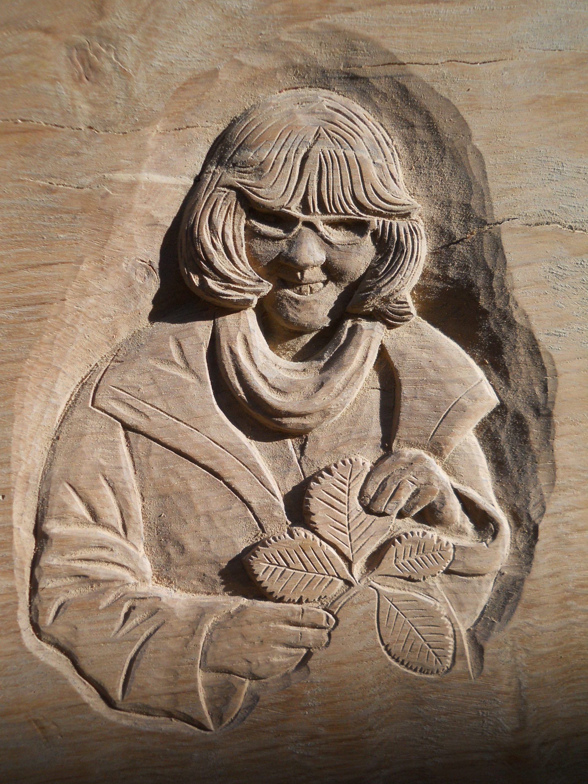 Woodcarving of Luibby Houston holding nleaves from Houston's whitebeam tree