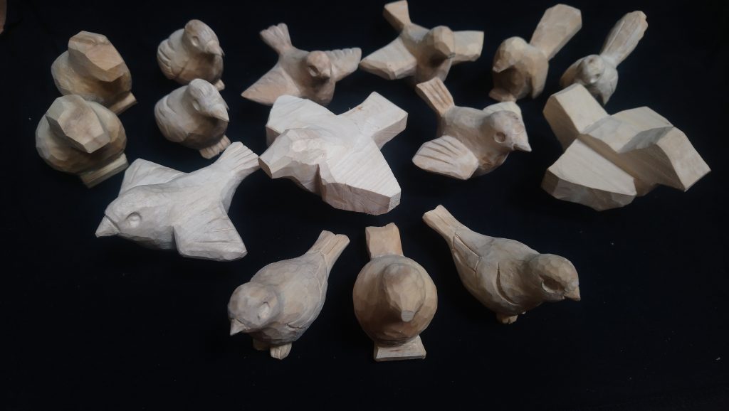 Small wooden carvings of birds in. various stage of completion. carvings are props for television production.